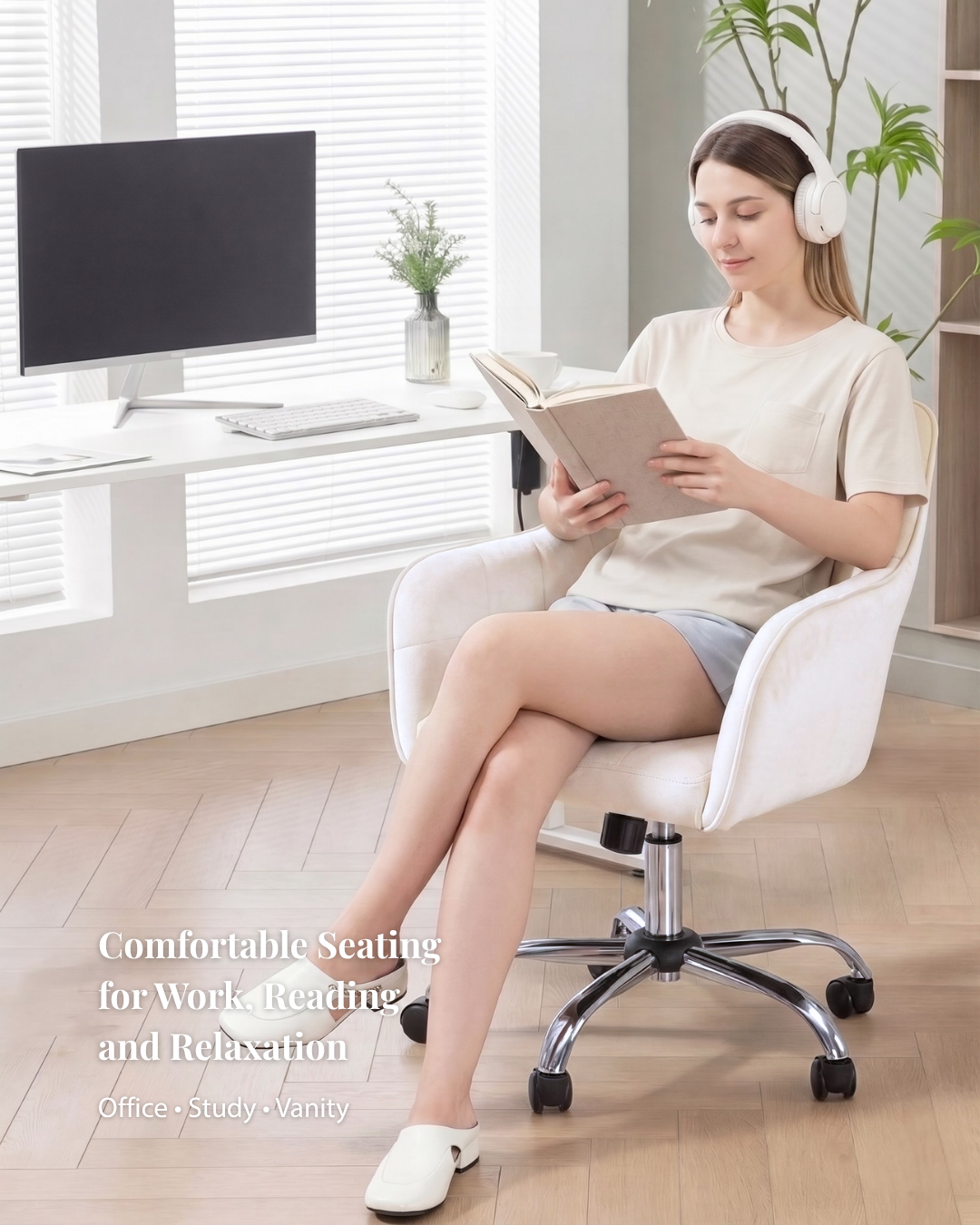 Woman sitting in a white office chair reading a book with headphones on, in a bright room