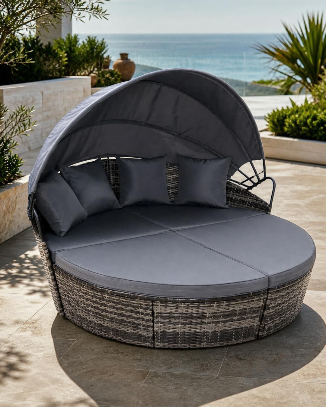 Round outdoor daybed with canopy on a patio with ocean view