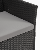 Gray cushion on a black wicker chair
