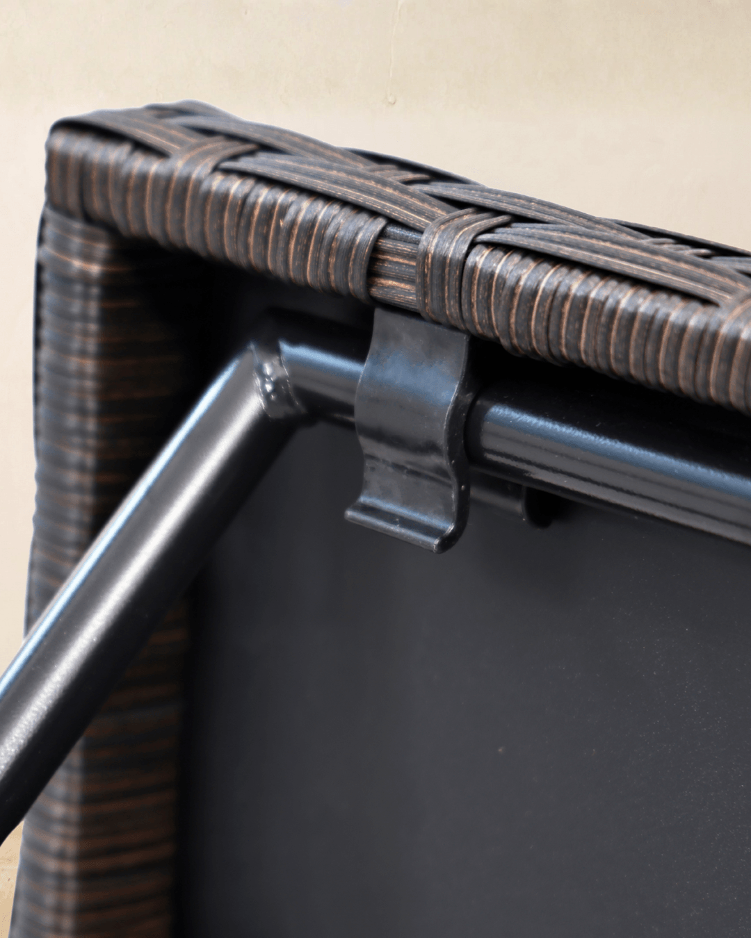 Close-up detail of a small rattan garden table with brown rattan tabletop