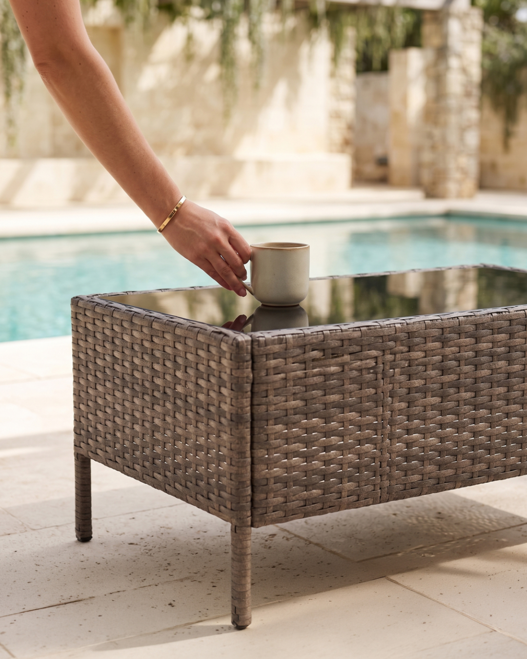 Placing a warm beverage on a glass-topped wicker coffee table