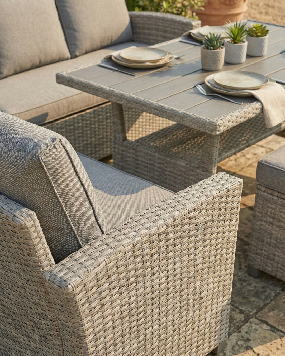 Grey rattan garden dining set showing corner sofa and dining table layout