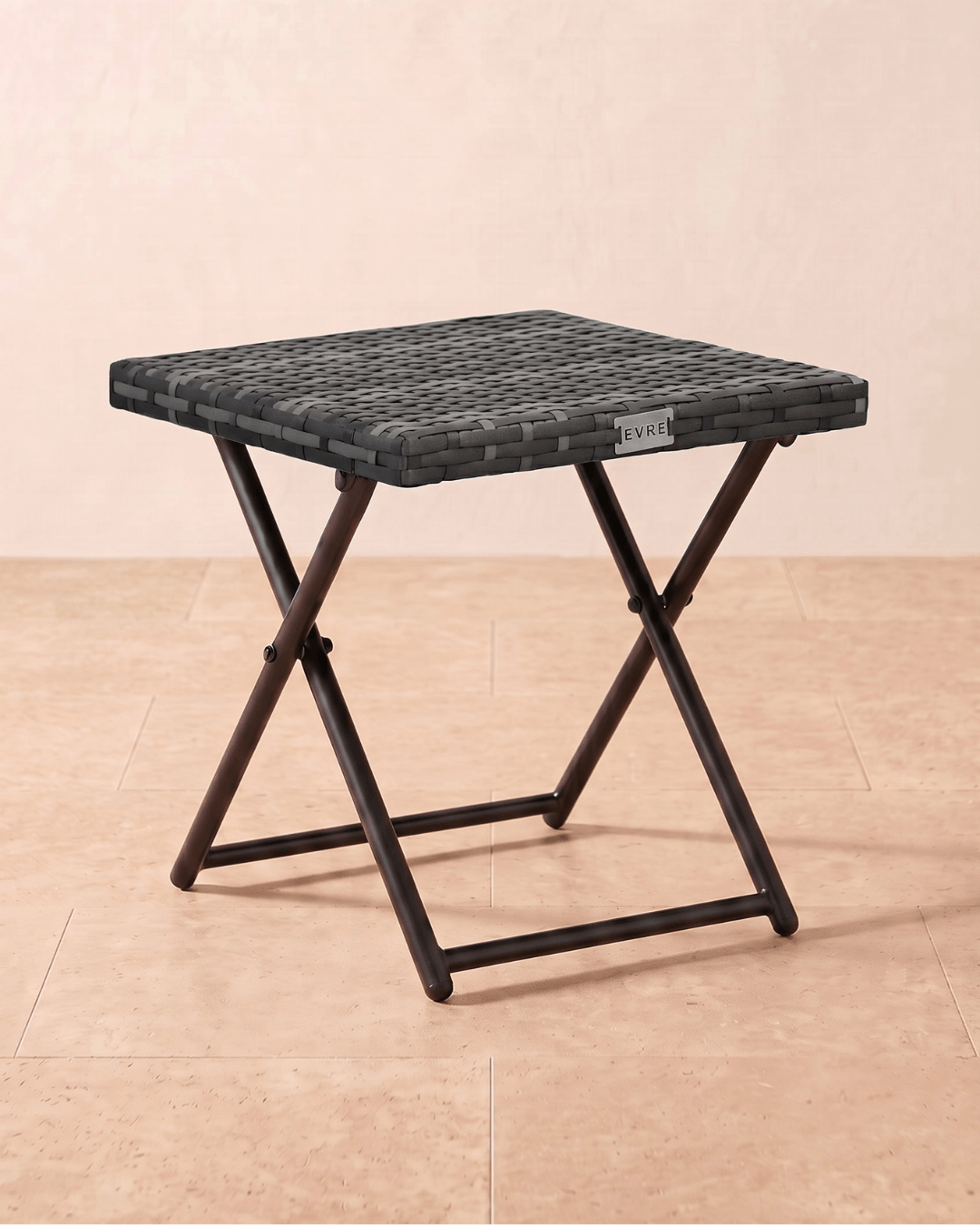 A small garden table in grey rattan with a folding metal frame