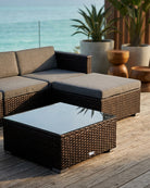 Outdoor patio furniture set with sectional sofa and coffee table on a wooden deck