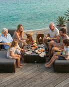 Family enjoying a meal together on a 7 piece rattan garden sofa set by the water