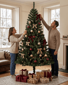 A man and a woman decorate a 7ft Christmas tree with red and gold ornaments, and beige ribbon bows