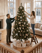 Decorating an 8ft Canada Spruce artificial Christmas tree with warm string lights, white bows, and gold and cream ornaments