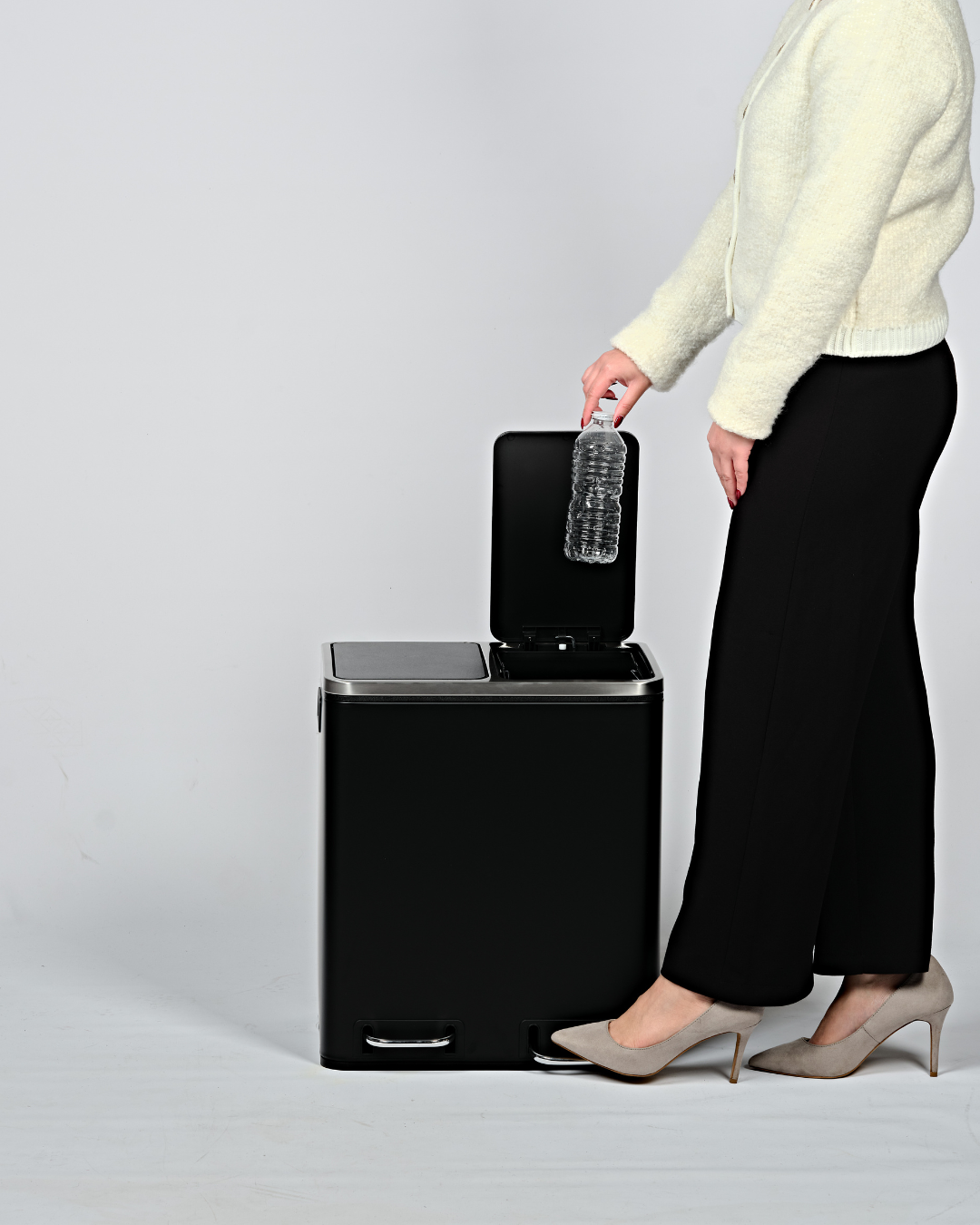 Disposing a plastic bottle in a black pedal bin