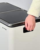 Lifting a white bin with built-in handles