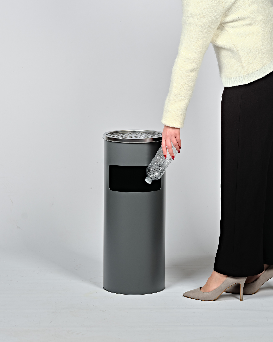Person disposing of a plastic water bottle in lobby bin