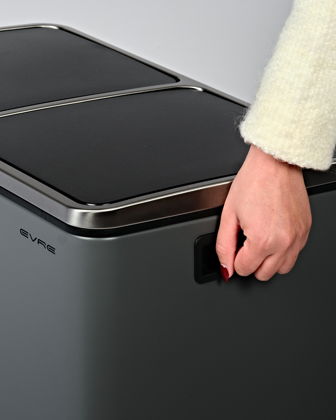 Lifting a grey bin with built-in handles