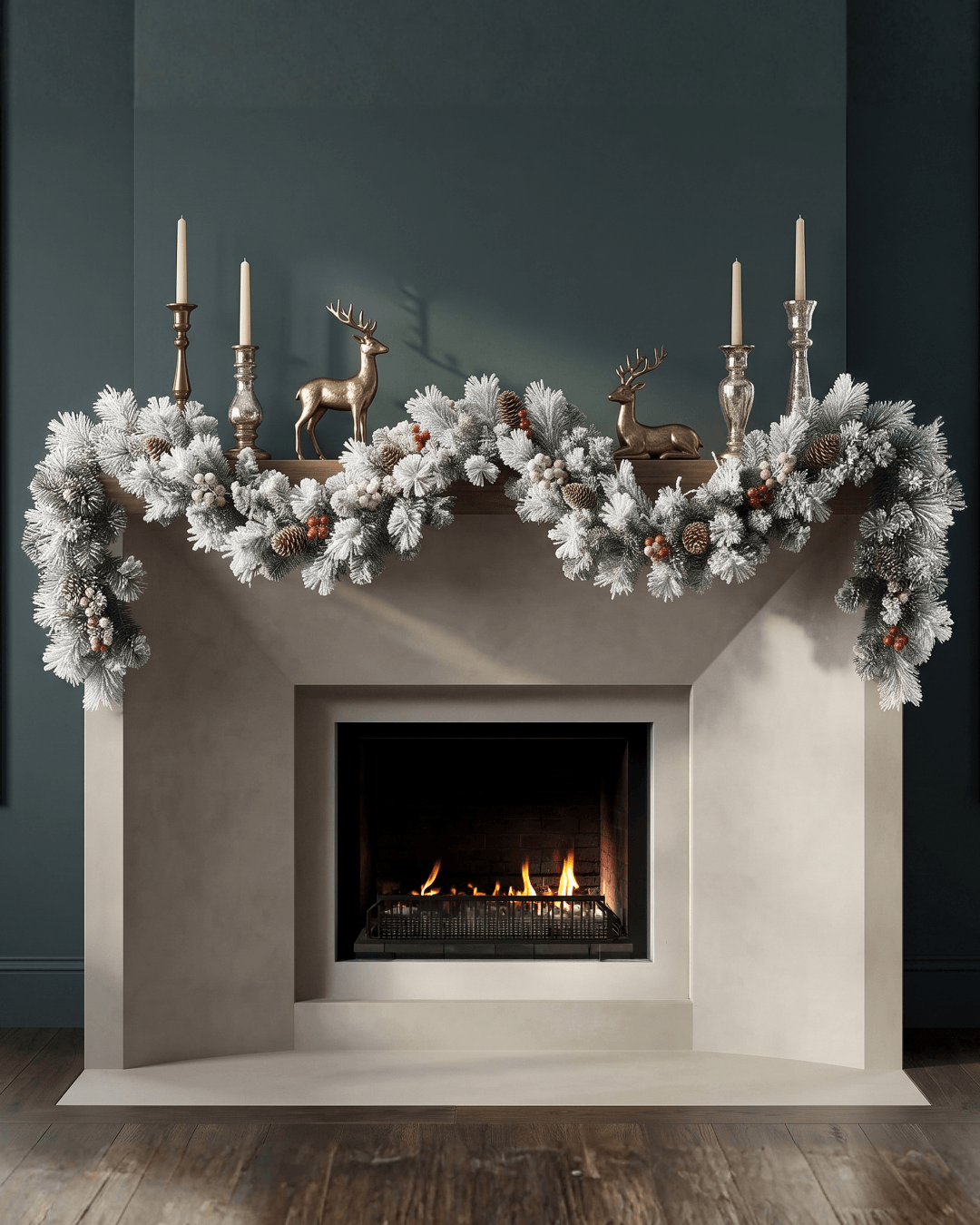White-frosted pine Christmas garland on a fireplace mantelpiece with bronze reindeer and silver candlesticks