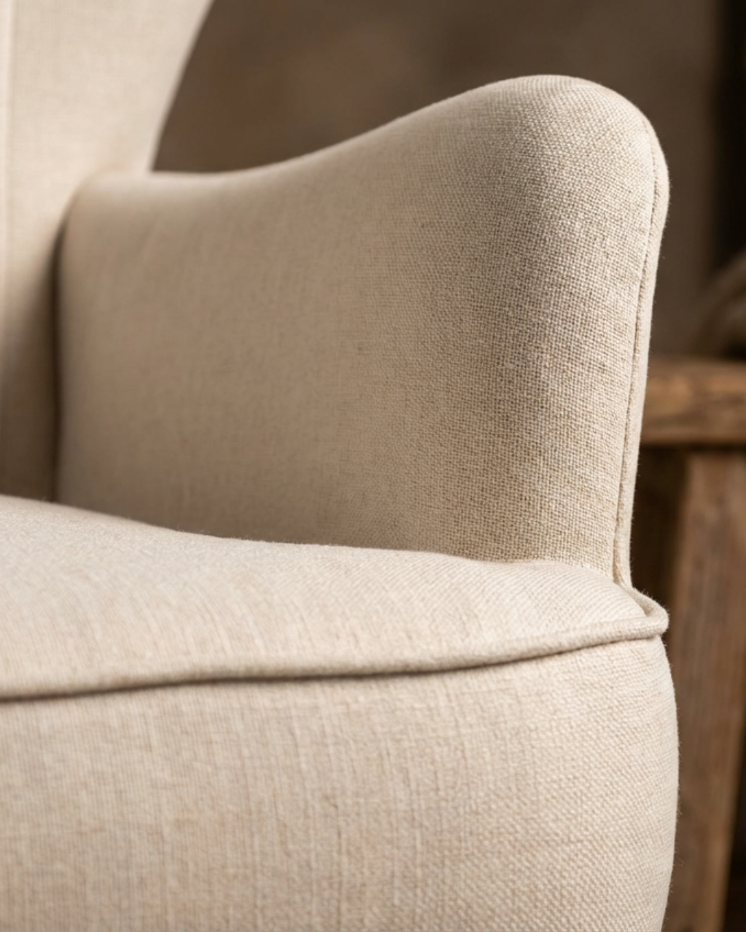 Close-up of a cream upholstered chair armrest