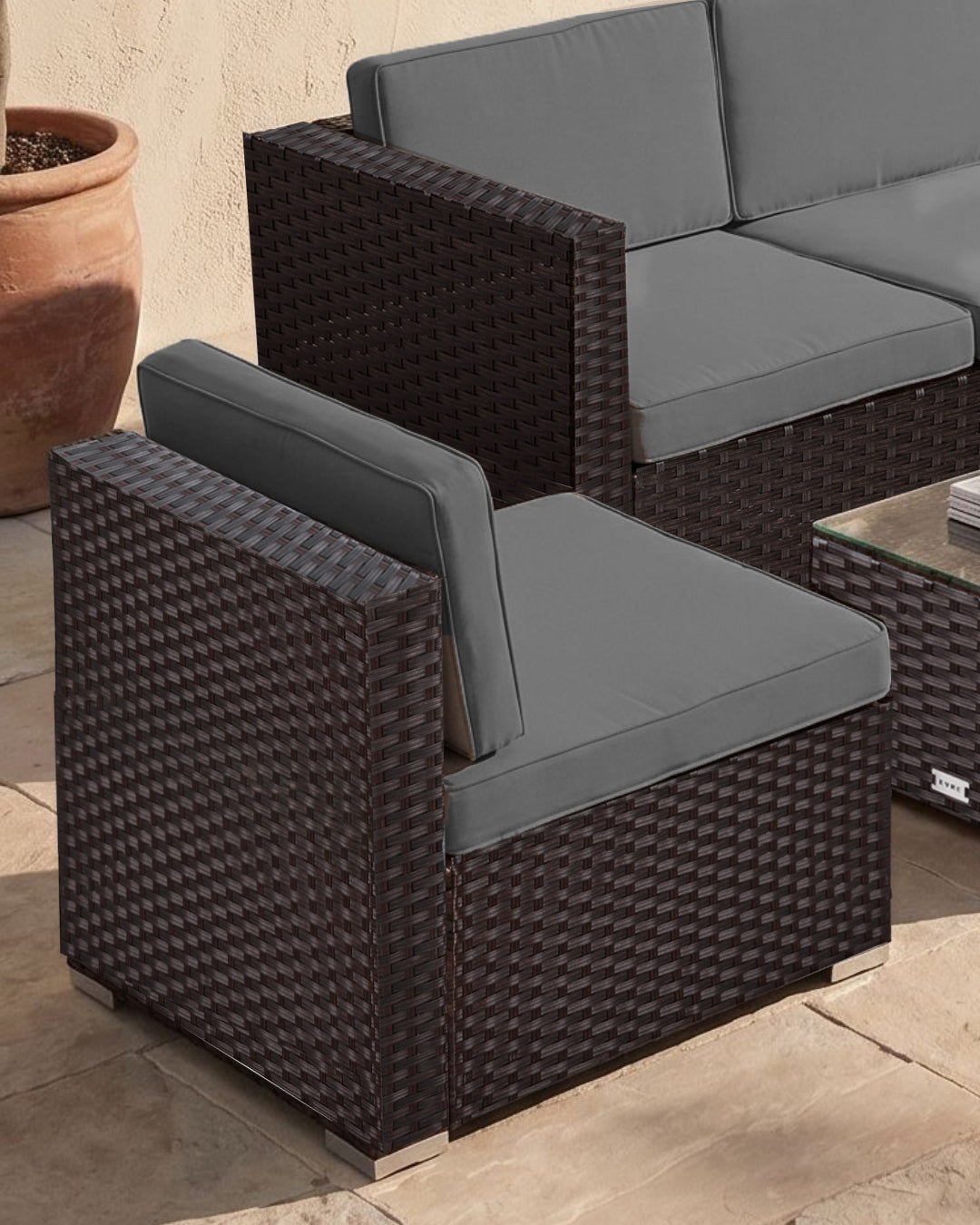 5-piece garden furniture set with wicker chairs and grey cushions on a patio