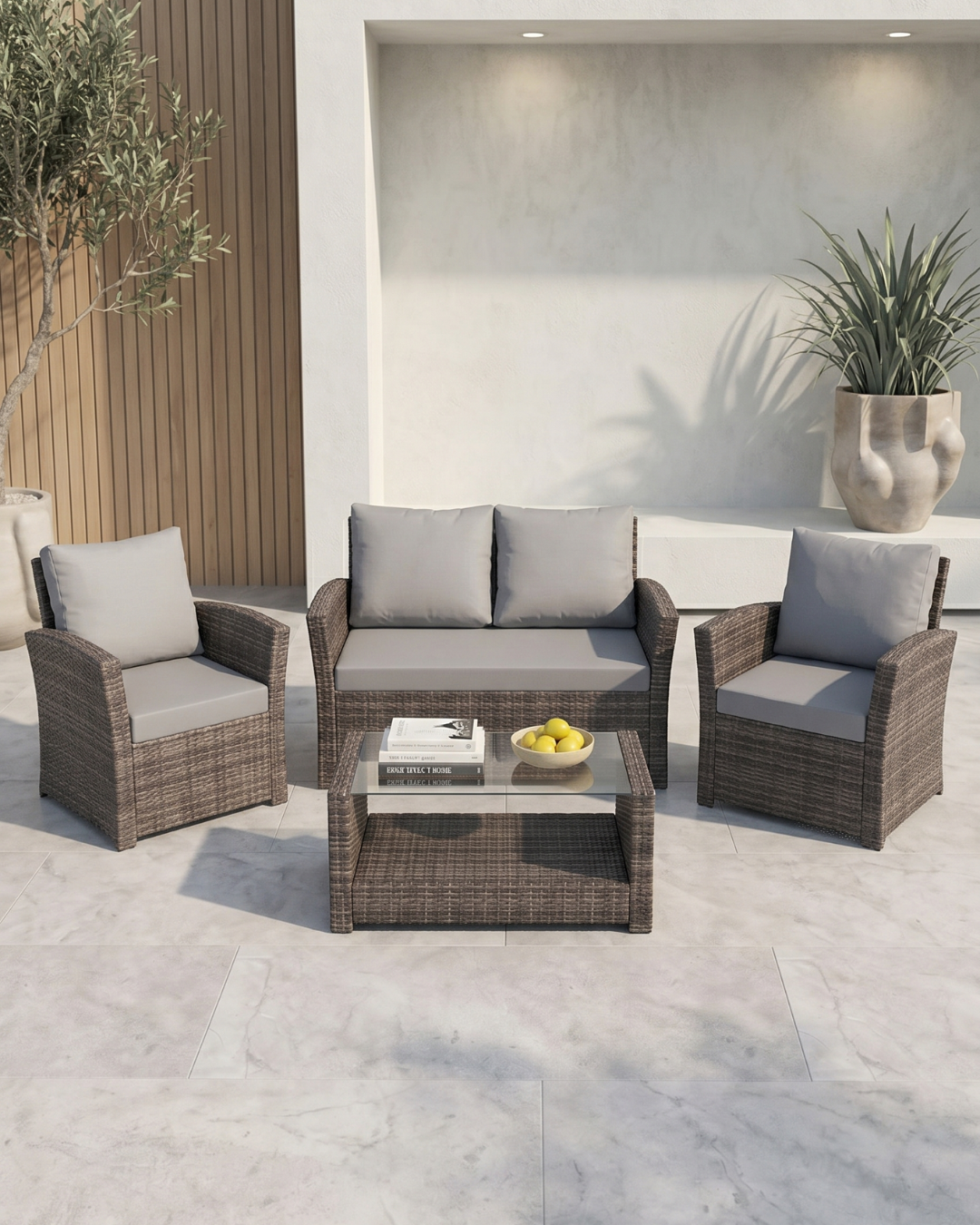 4-piece patio furniture with grey cushions and glass-top coffee table on a concrete patio