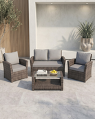 4-piece patio furniture with grey cushions and glass-top coffee table on a concrete patio