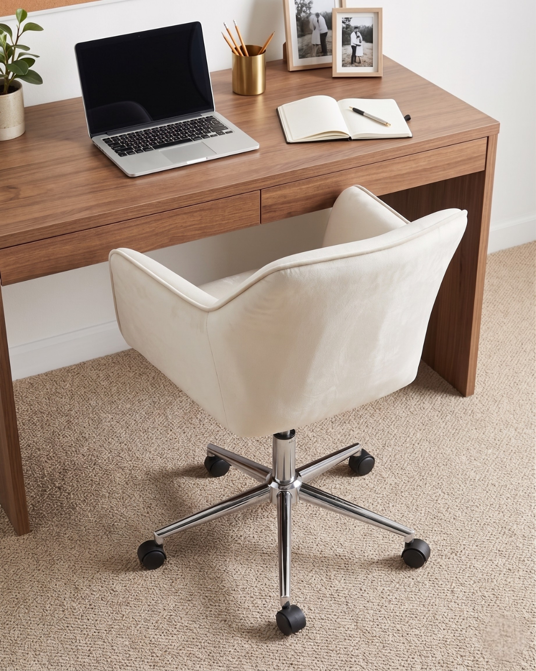 Wooden desk with a laptop, notebook, and office supplies, accompanied by a white office chair