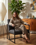 Woman sitting in a grey armchair in a lounge