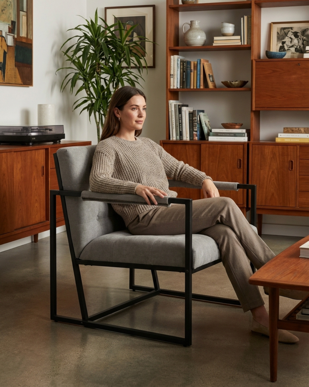 Woman sitting in a modern grey armchair in a cosy lounge