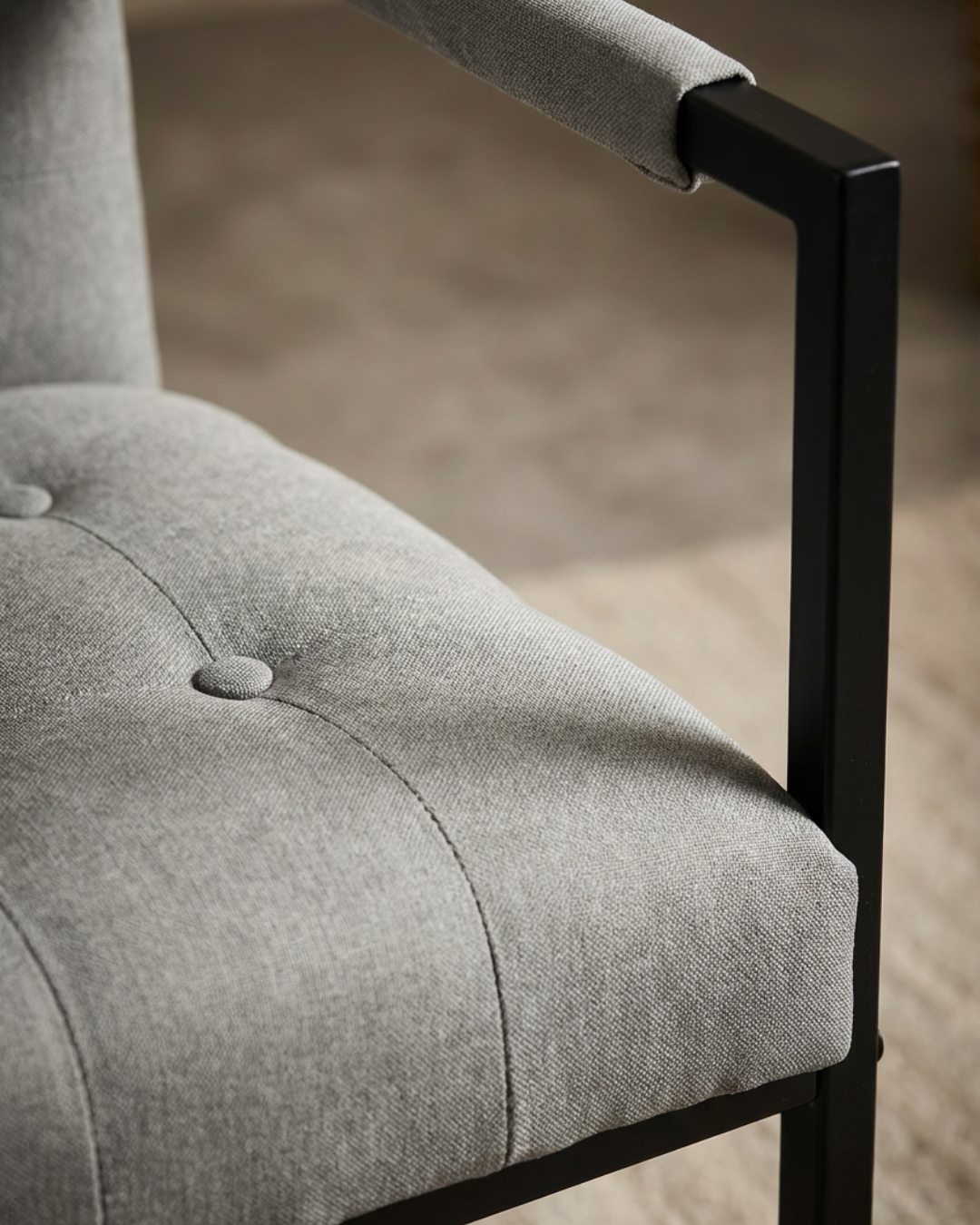 Close-up of a grey upholstered chair with black metal frame