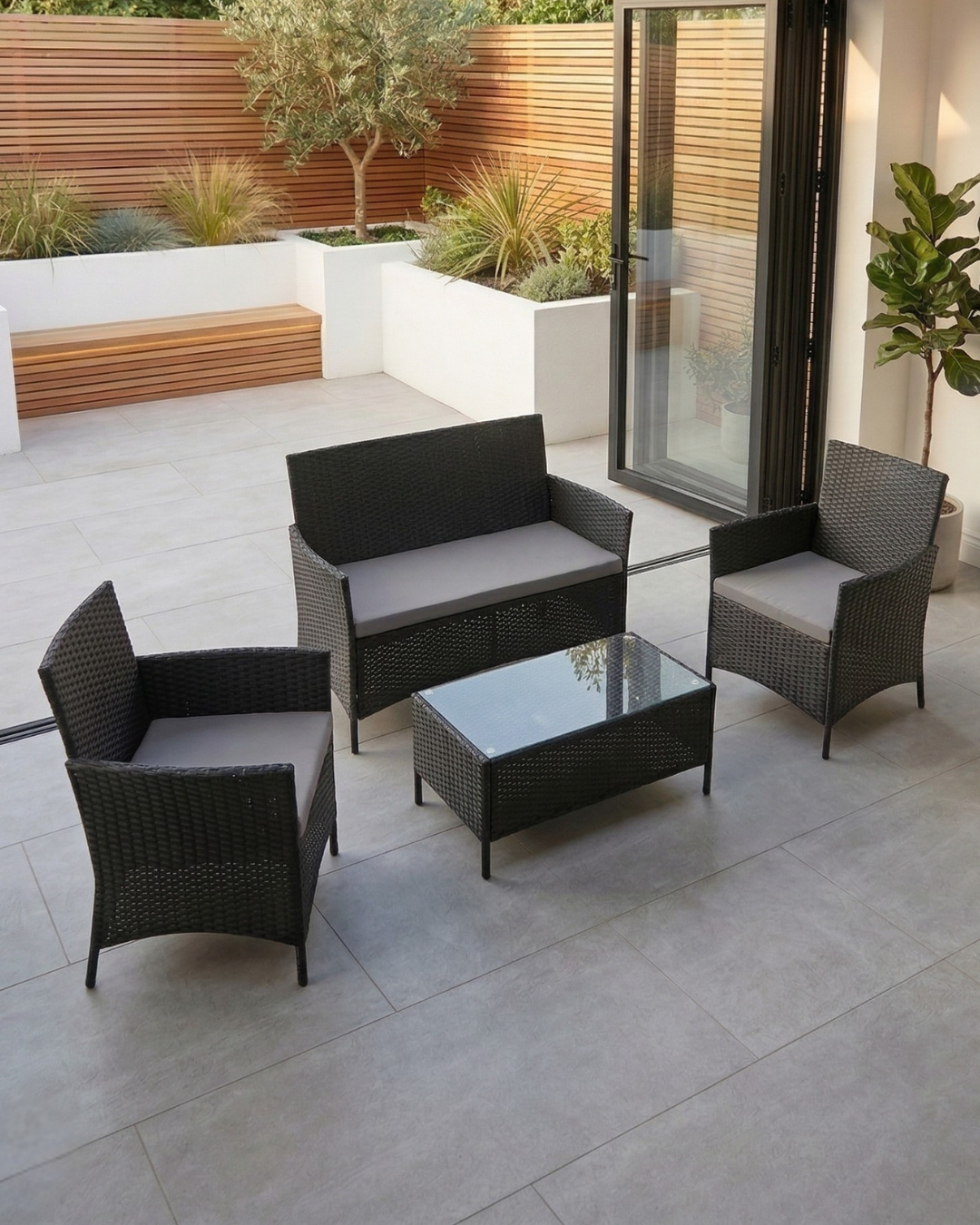 Outdoor patio set with black wicker furniture on a stone patio