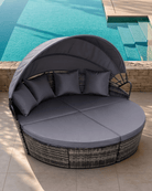 Round outdoor daybed with canopy on a patio with ocean view