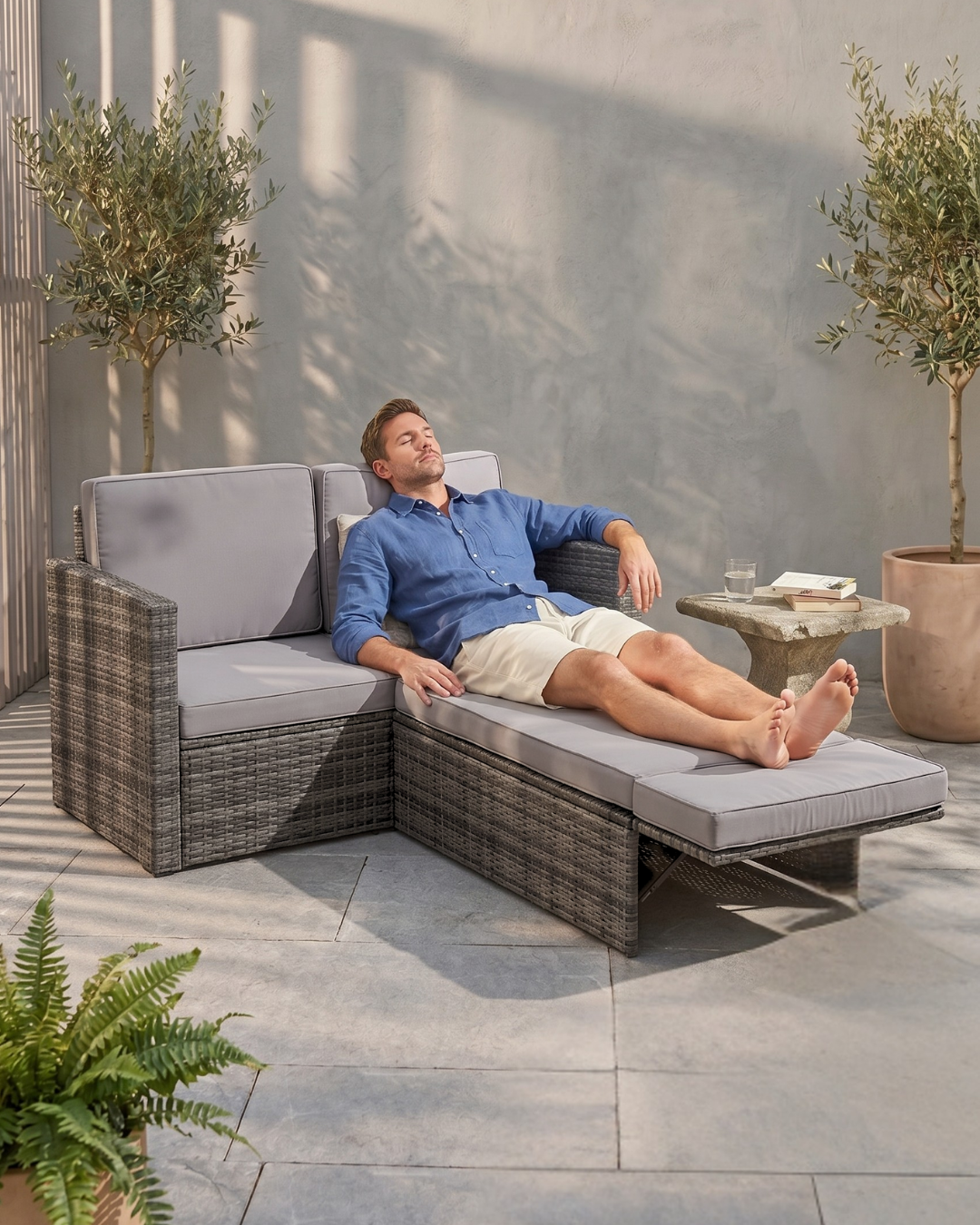Man relaxing on a Modular 2 Seater Rattan Garden Sofa Lounger