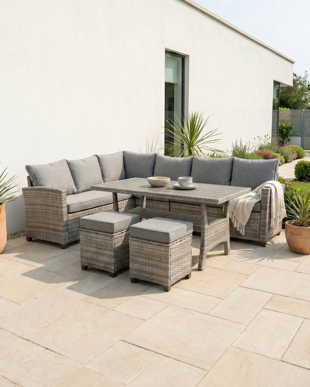 8 seater grey rattan corner outdoor dining set with table and chairs in garden setting
