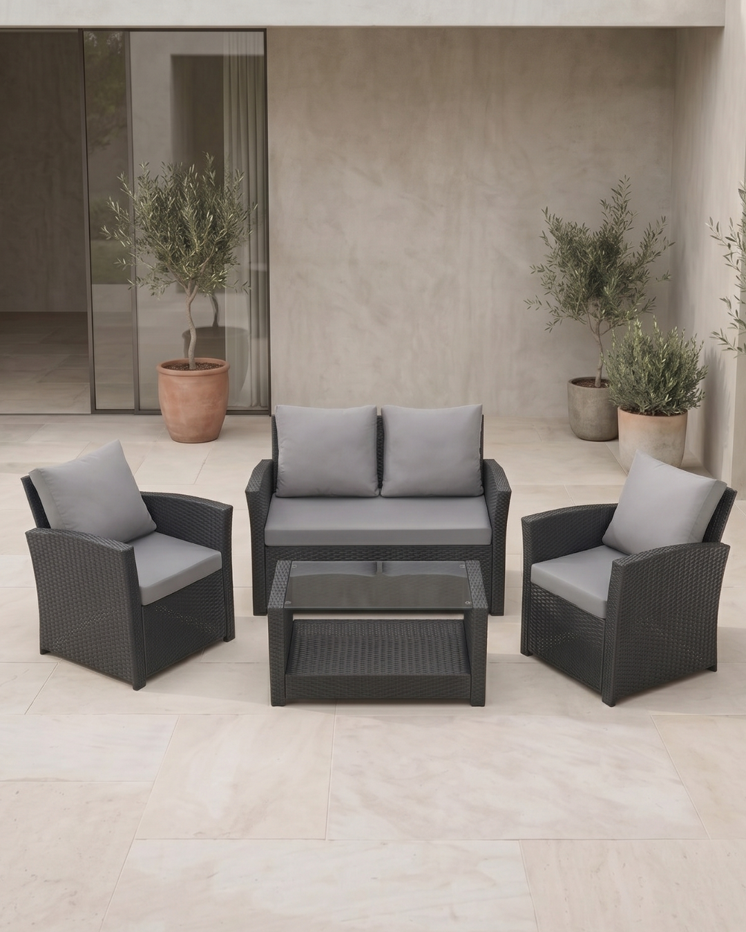 Black rattan 4-piece patio set with grey cushions on a patio