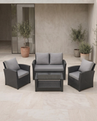 Black rattan 4-piece patio set with grey cushions on a patio