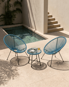 Teal blue egg chair set on a stone patio