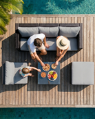 Family enjoying a meal on a black rattan garden furniture set by the pool