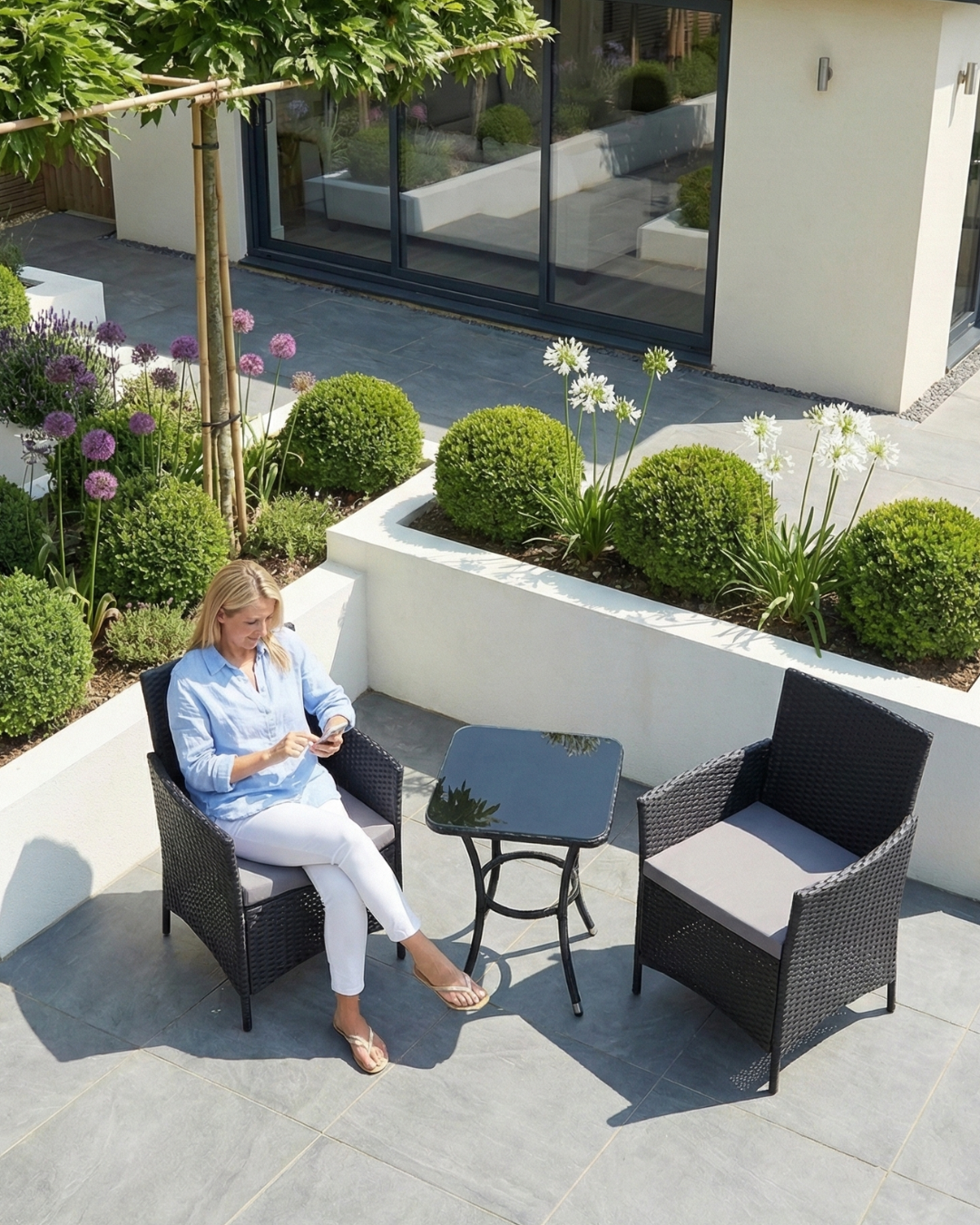 Woman sitting on a black garden bistro set