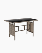 Dining table with black glass top and brown wicker frame