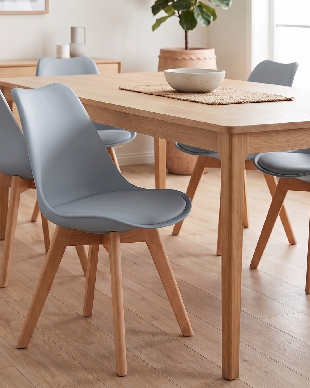 Dining room with wooden table and grey chairs on a wooden floor