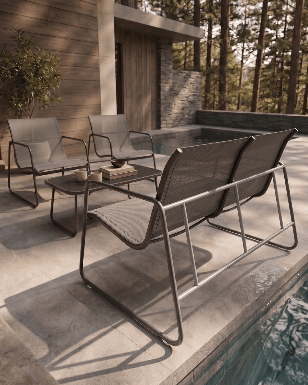 Grey patio chairs and table set outdoors by the pool