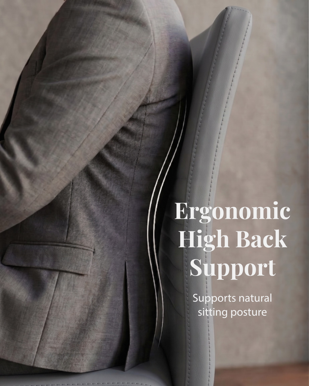 Person in a suit sitting on an ergonomic high back grey chair