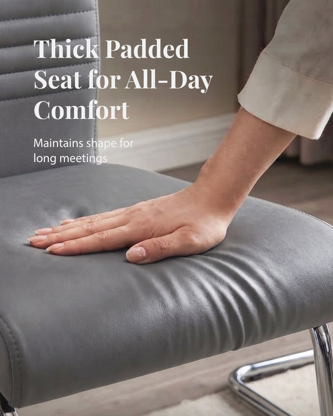 Hand resting a hand on a thick padded grey chair seat