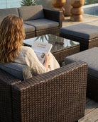 Woman reading a book on outdoor patio furniture