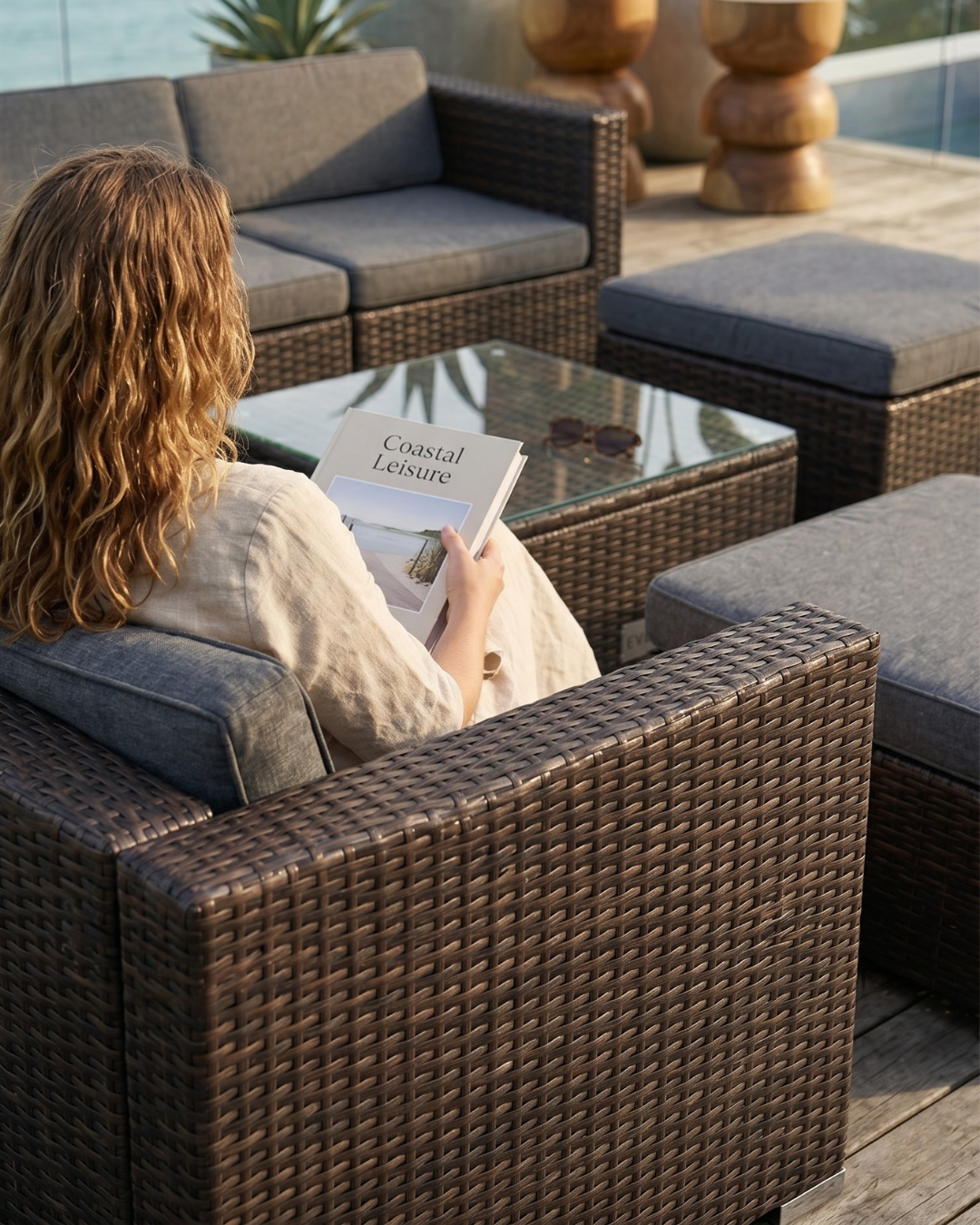 Woman reading a book on outdoor patio furniture