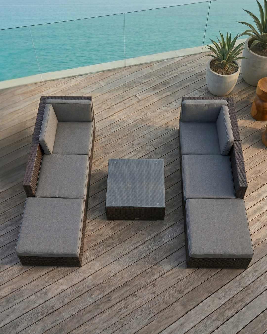 Modular rattan garden furniture set on a wooden deck overlooking the ocean
