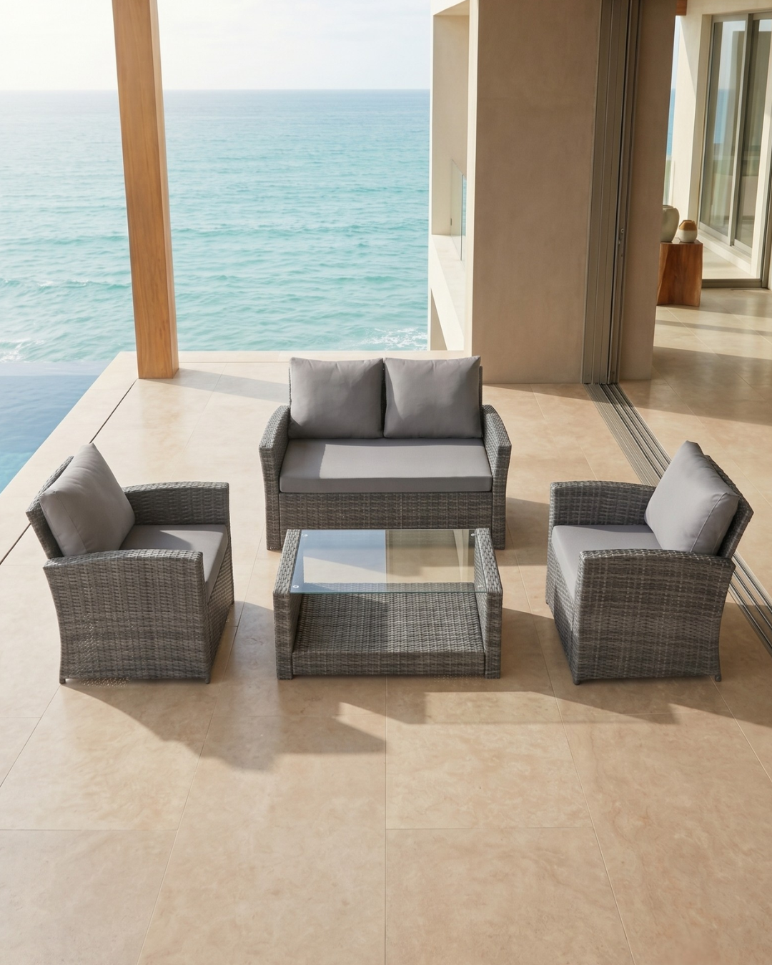 Outdoor furniture patio set with grey cushions on a patio with ocean view
