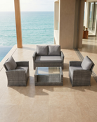 Outdoor furniture patio set with grey cushions on a patio with ocean view