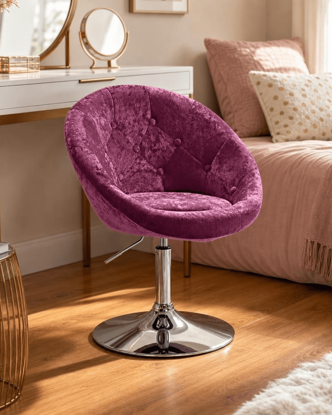 A tufted pink velvet swivel armchair with a chrome pedestal base, set in a warm, sunlit bedroom next to a bed with pink bedding