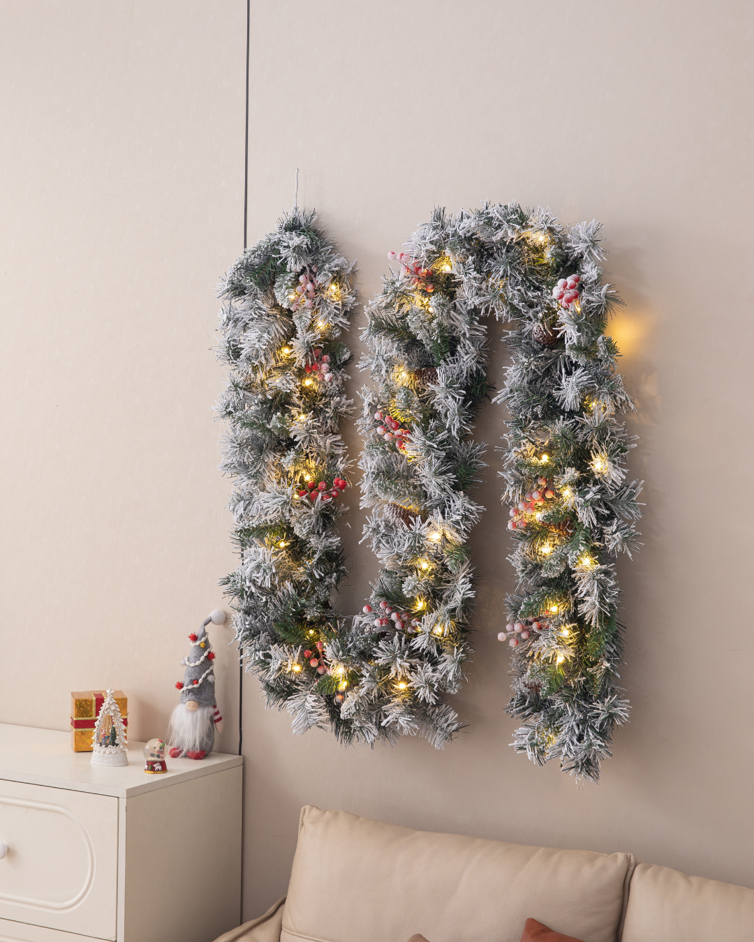 Christmas garland with LED lights on a wall above a sofa