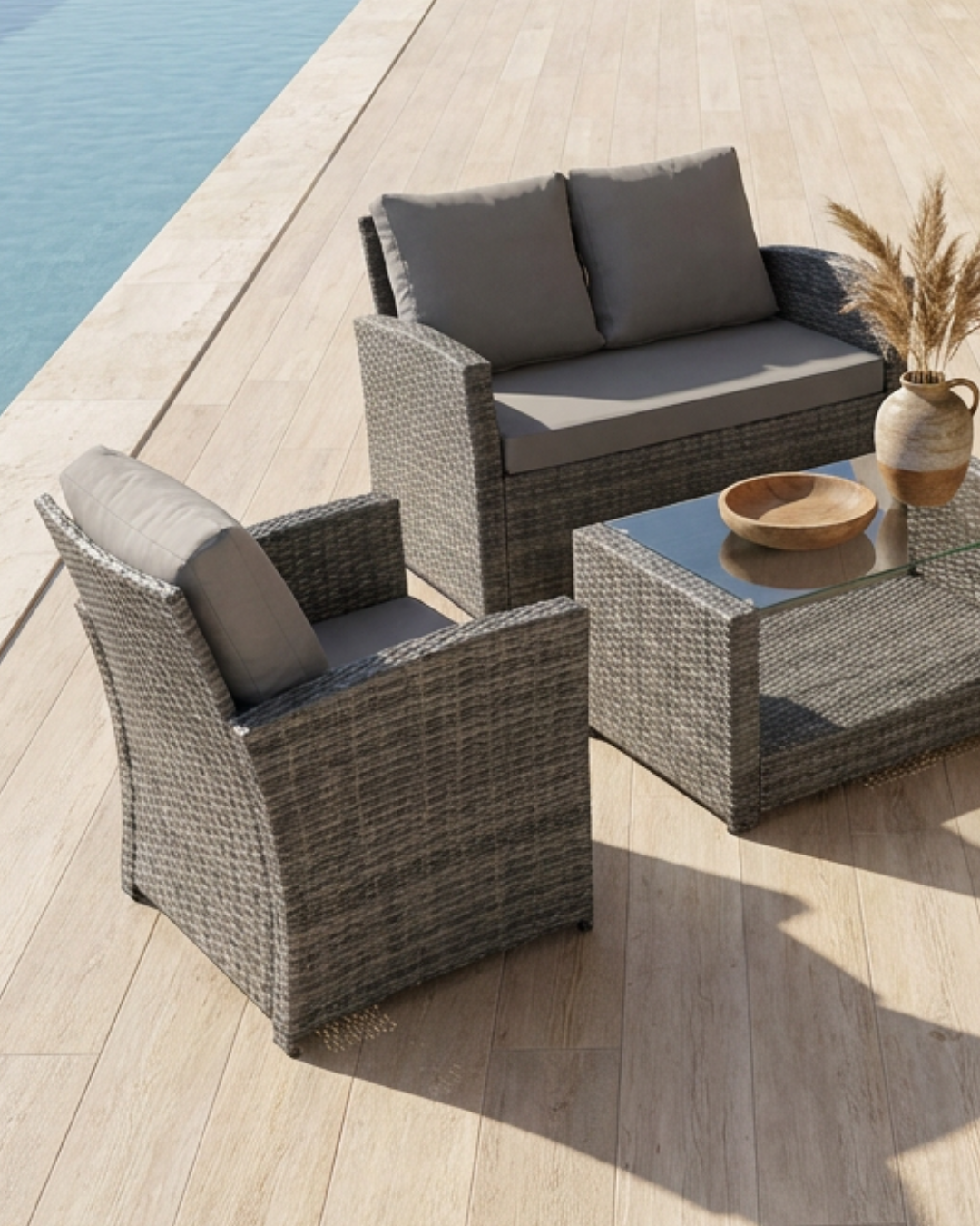 Grey rattan patio set with cushions by the pool