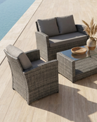 Grey rattan patio set with cushions by the pool