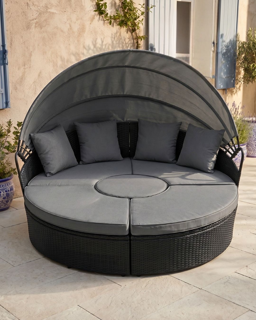 Black rattan patio day bed with canopy and grey cushions