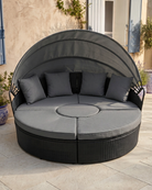 Black rattan patio day bed with canopy and grey cushions