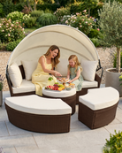 Woman and child enjoying a picnic on a round sofa daybed with canopy